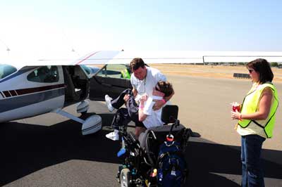 Kevin Kingston helps his son Keith into the plane